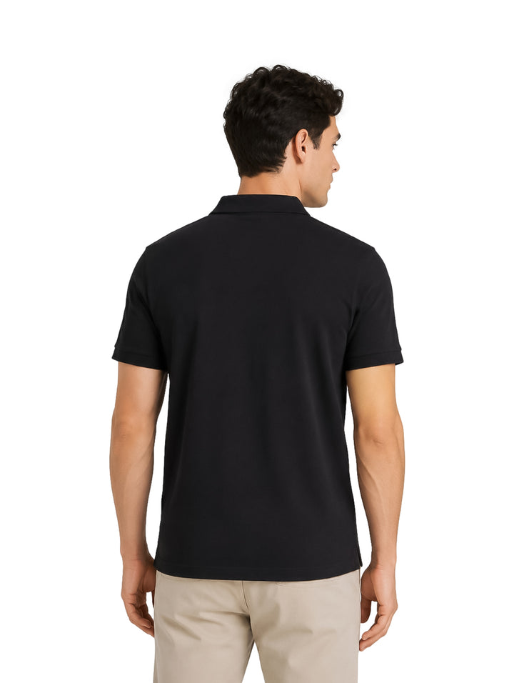 Hombre modelando una playera polo DKNY de color negro con cuello y botones.