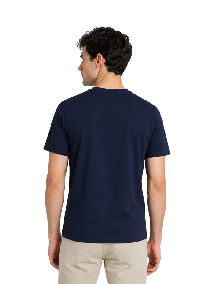 Hombre vistiendo playera color navy de marca DKNY con logotipo blanco en el pecho.