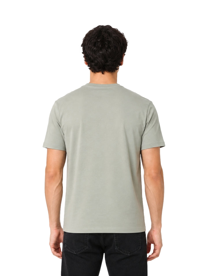 Hombre vistiendo playera DKNY color green tea de manga corta y cuello redondo.