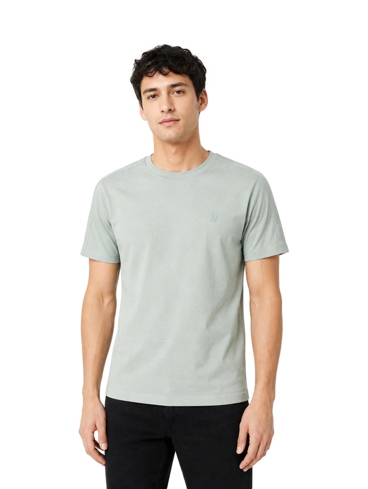 Hombre vistiendo playera DKNY color verde parkway de manga corta y cuello redondo.