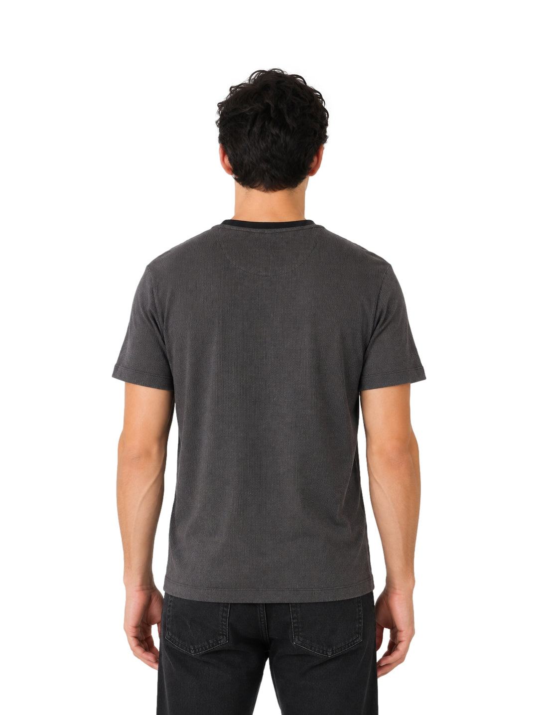Hombre vistiendo una playera DKNY de color negro con cuello redondo y manga corta.