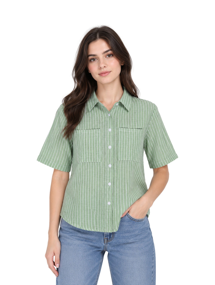 Mujer vistiendo una camisa verde de manga corta con rayas blancas verticales y botones frontales.
