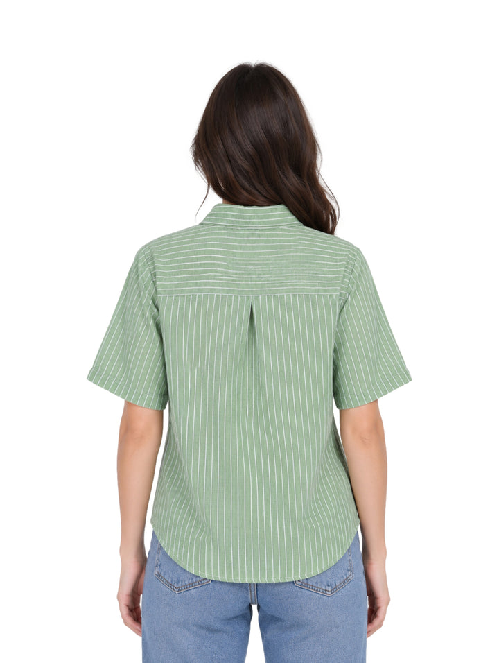 Mujer vistiendo una camisa verde de manga corta con rayas blancas verticales y botones frontales.