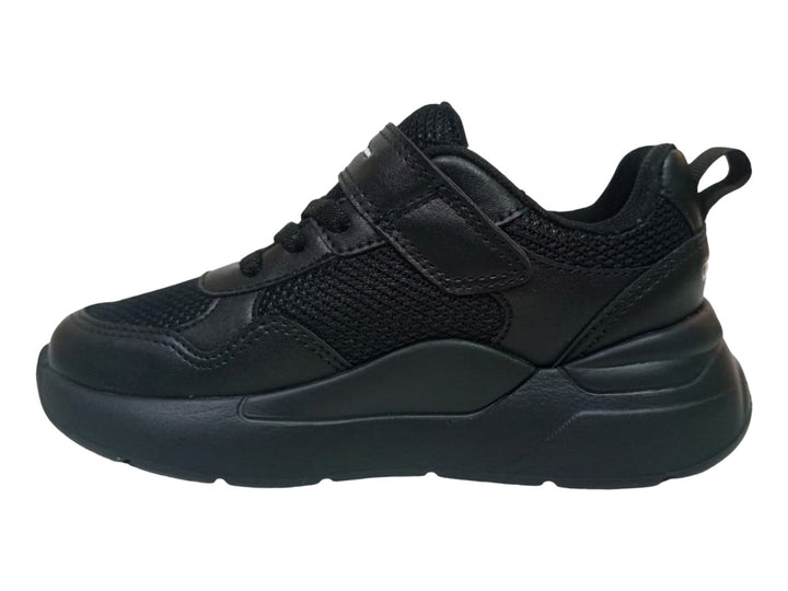Tenis Champion Motion School color negro con cierre de velcro y suela gruesa sobre fondo blanco.