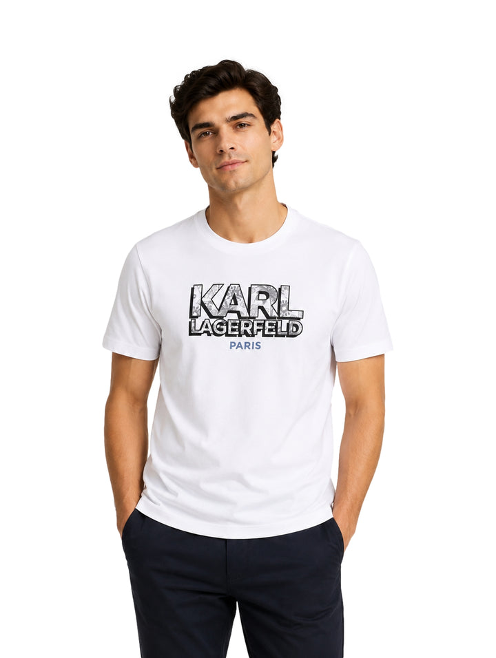 Hombre usando playera blanca de manga corta con estampado de Karl Lagerfeld en el pecho.