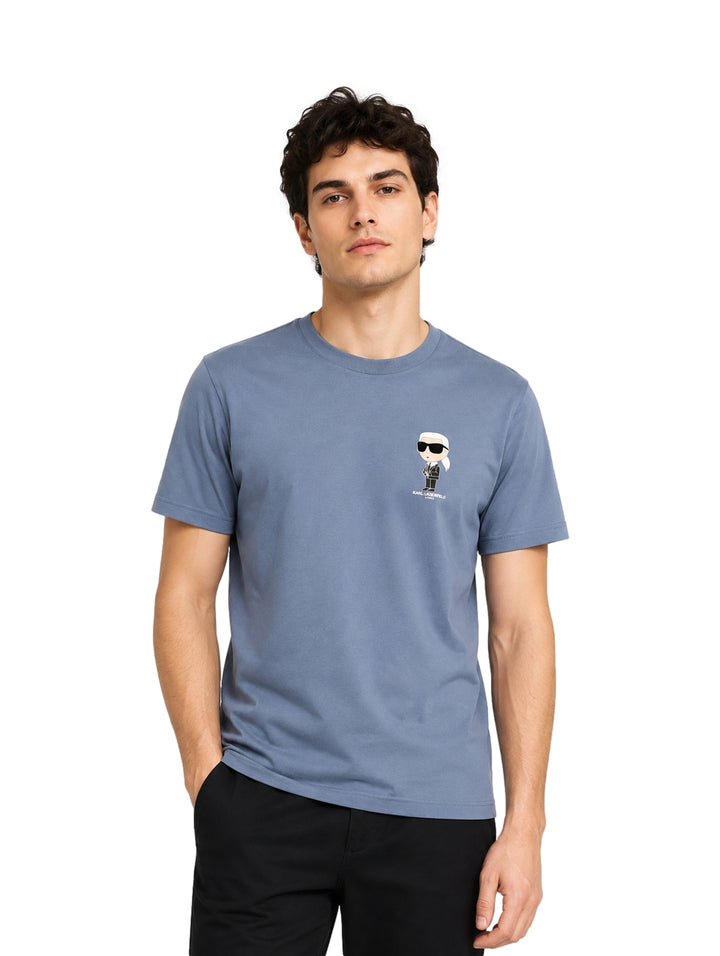 Hombre vistiendo una playera azul de manga corta con un pequeño estampado de Karl Lagerfeld en el pecho.