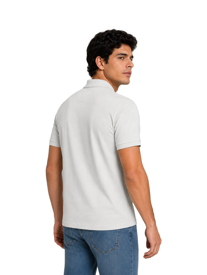 Hombre vistiendo una playera polo blanca de manga corta con cuello y botones.