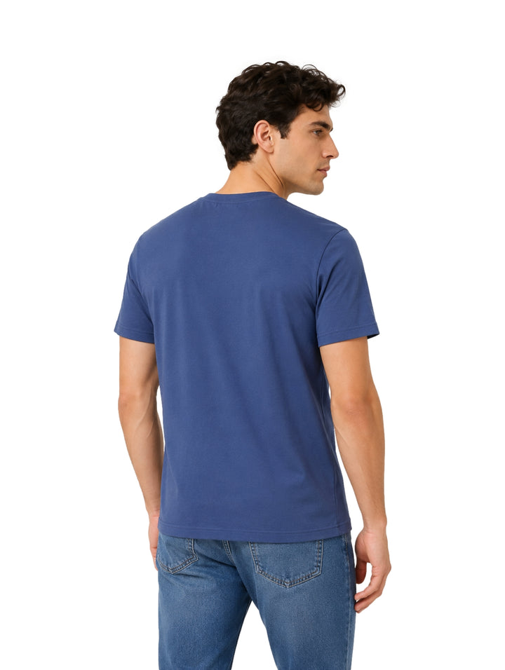 Hombre vistiendo una playera azul de manga corta y cuello redondo.
