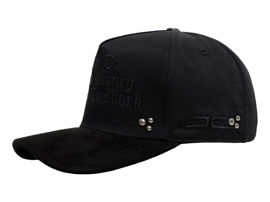 Gorra negra de JC HATS con bordado frontal y detalles metálicos laterales.