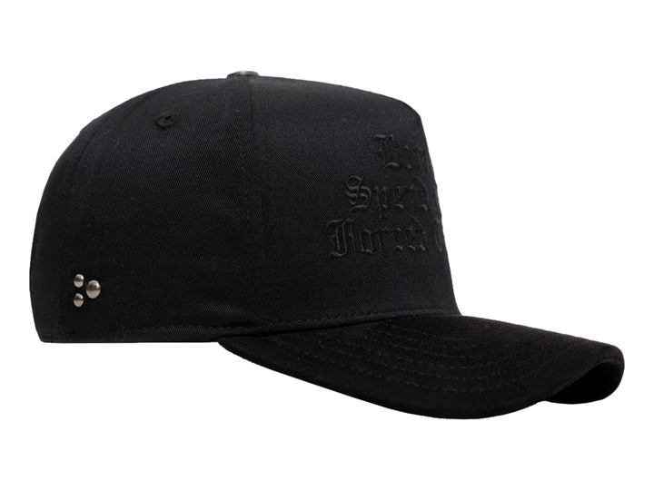 Gorra negra de JC HATS con bordado frontal y detalles metálicos laterales.