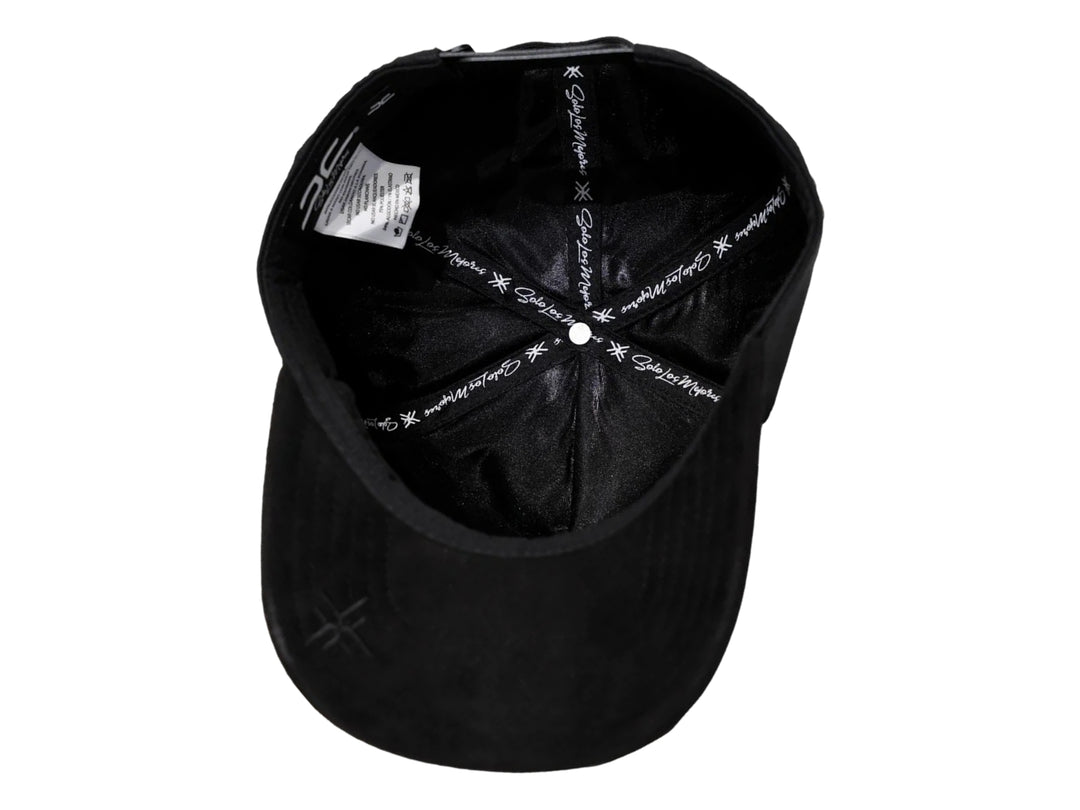 Gorra negra de JC HATS con bordado frontal y detalles metálicos laterales.
