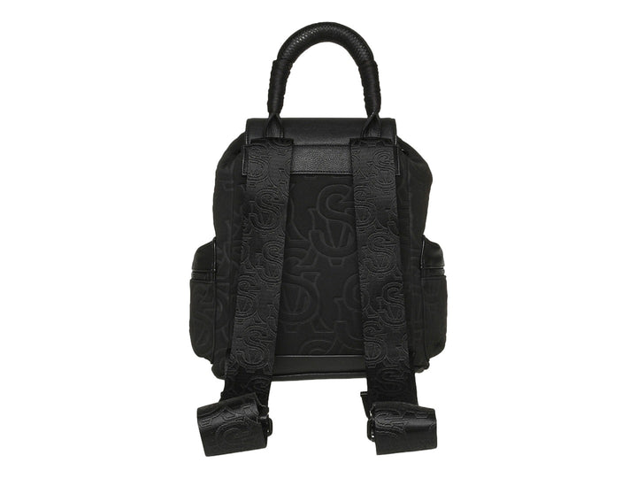Mochila Steve Madden color negro con estampado monocromático, detalles en piel sintética y asa superior.