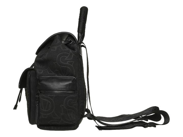 Mochila Steve Madden color negro con estampado monocromático, detalles en piel sintética y asa superior.