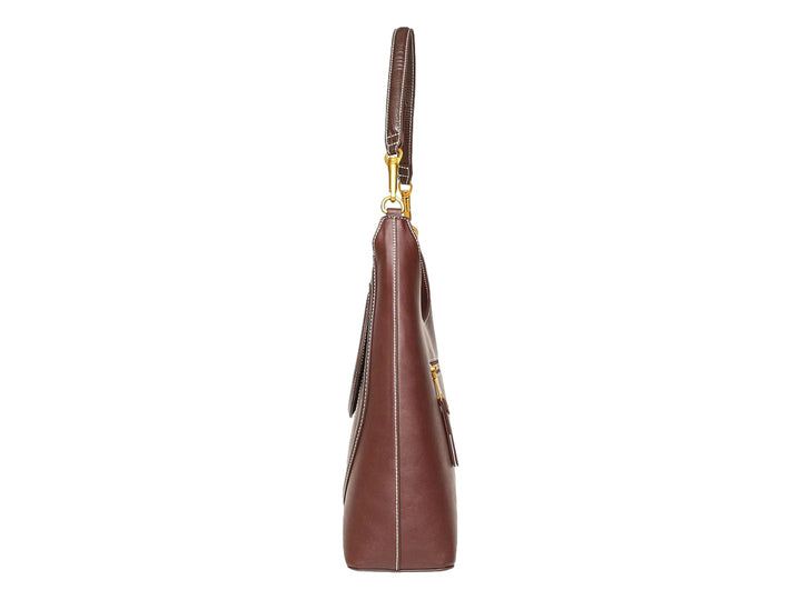 Bolso hobo Steve Madden color chocolate con detalles en dorado y costuras blancas contrastantes.