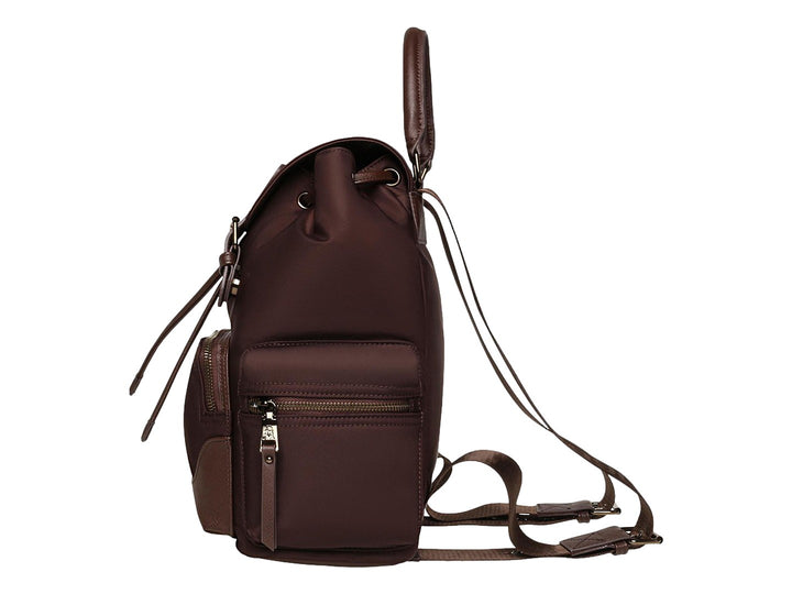 Mochila Steve Madden color café con detalles en bronce, asa superior y bolsillos laterales.