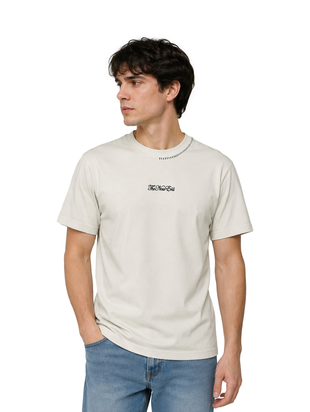 Hombre vistiendo una playera de manga corta color arena con cuello redondo y un pequeño detalle de texto en el pecho.