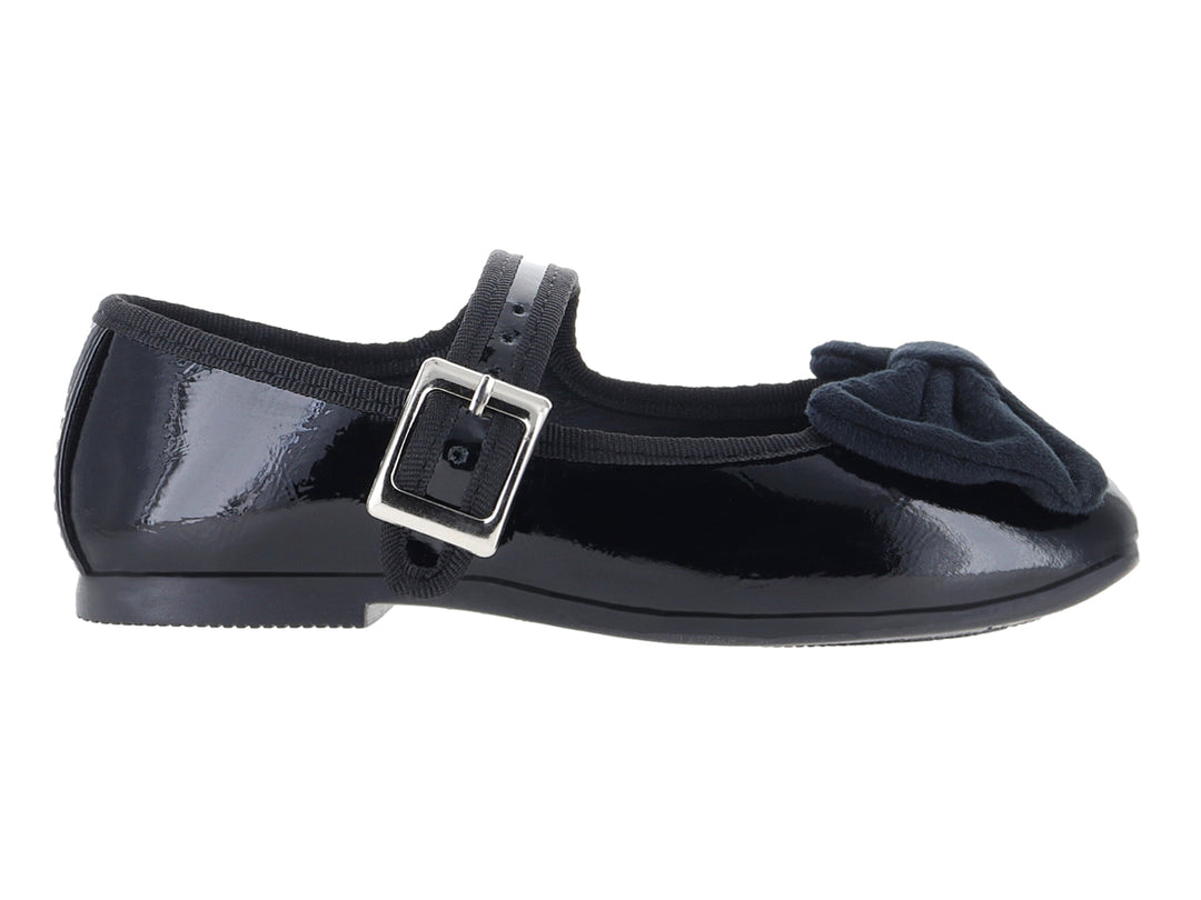 Zapato tipo ballerina negro de charol con moño y correa con hebilla plateada.
