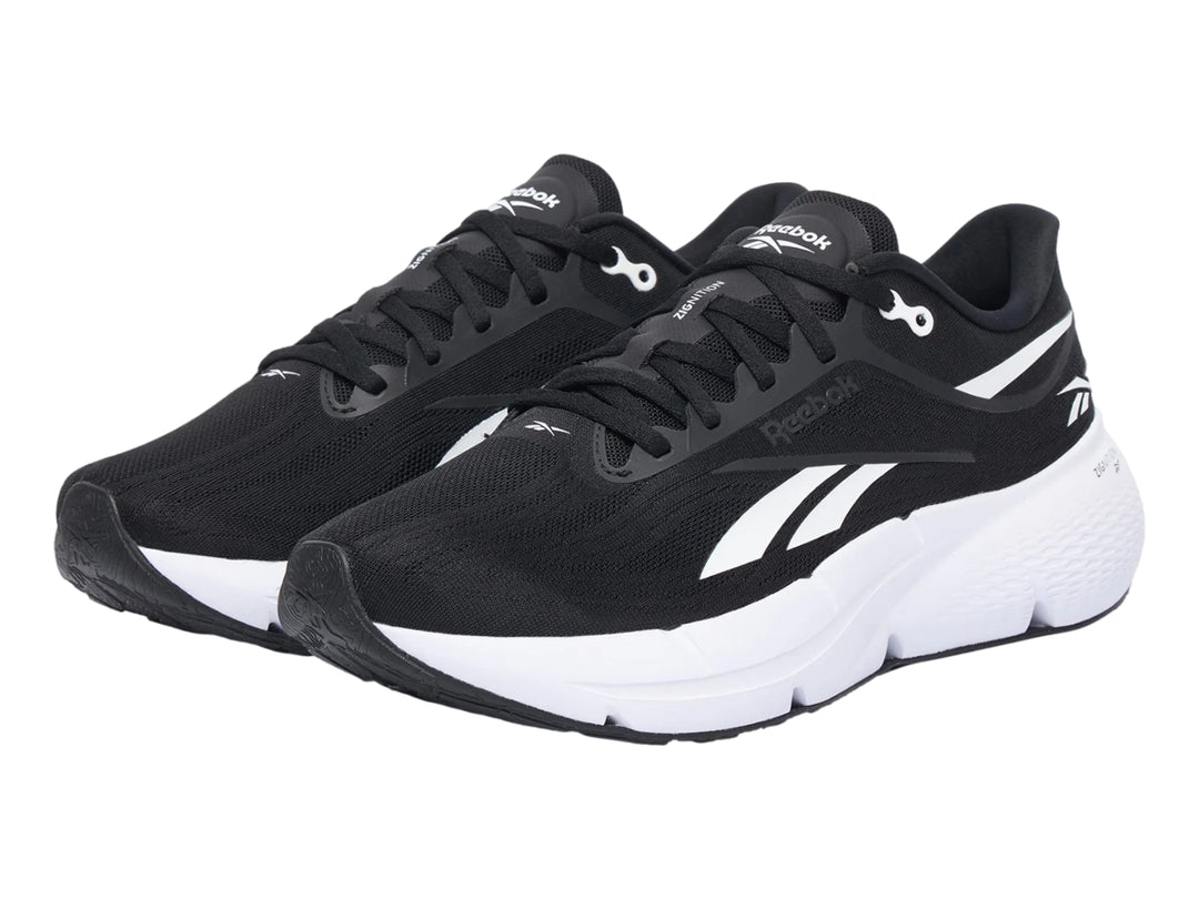 Tenis deportivos Reebok Zignition color negro con suela blanca y detalles laterales en blanco.