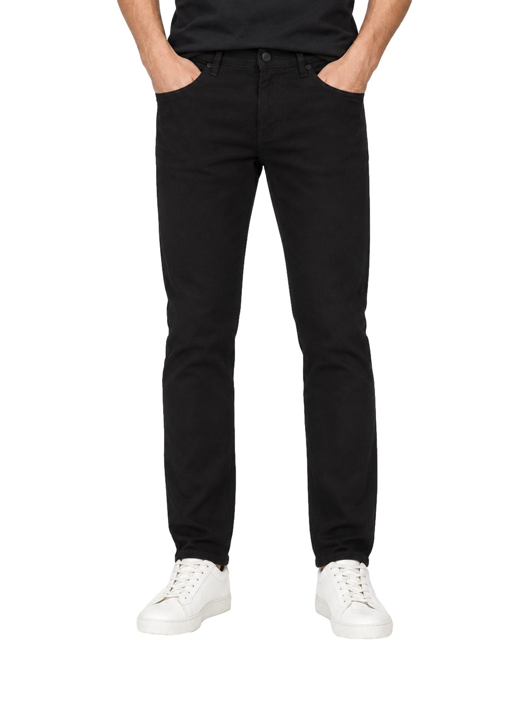 Hombre vistiendo jeans rectos de color negro con tenis blancos sobre fondo blanco.