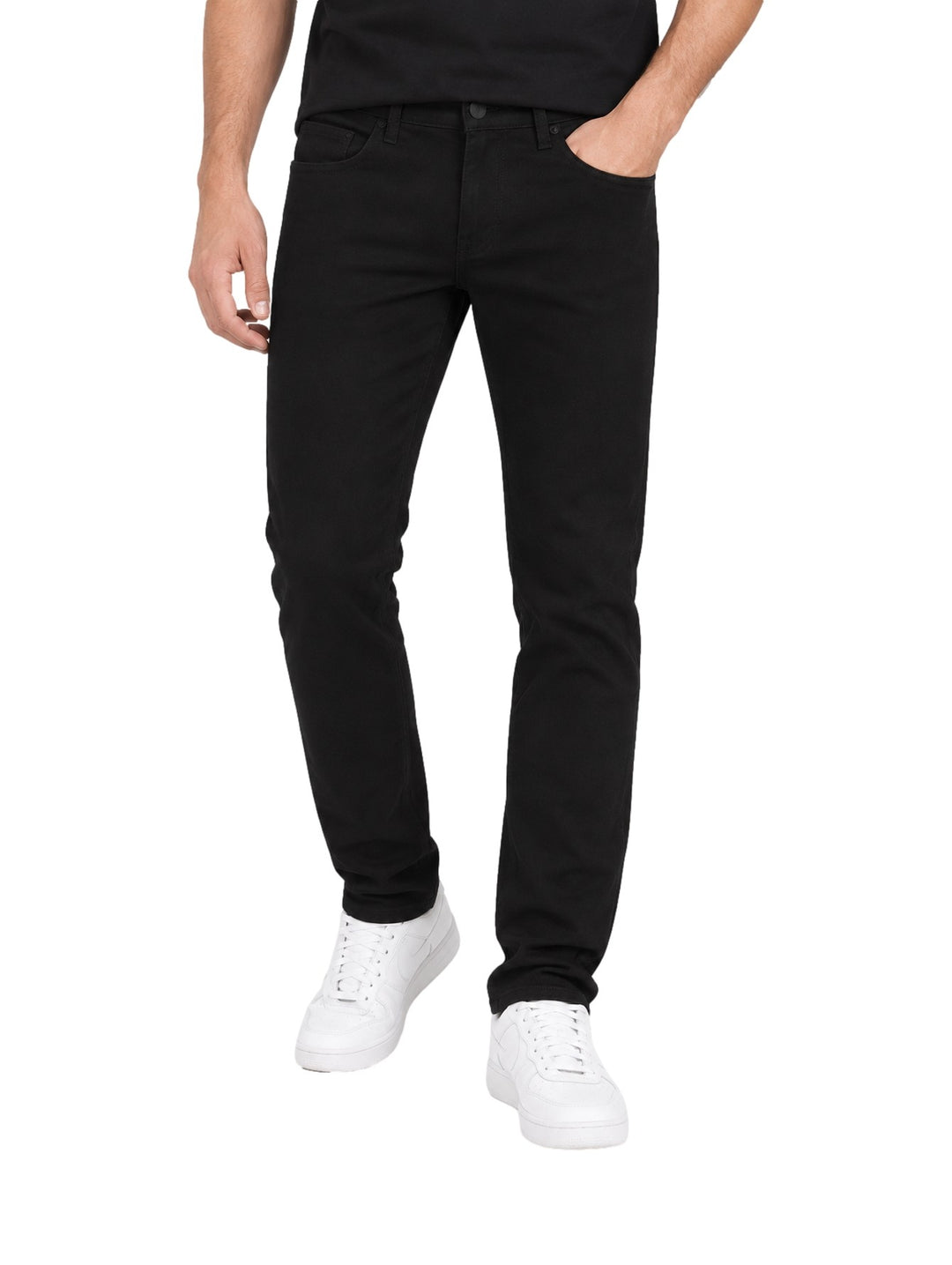 Hombre vistiendo jeans rectos de color negro con tenis blancos sobre fondo blanco.
