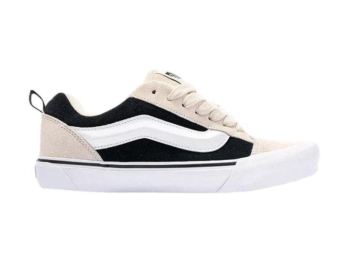 Tenis Vans Knu Skool color beige y negro con suela blanca y cordones beige.