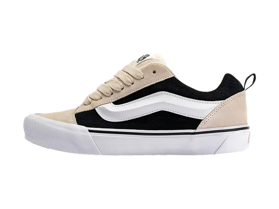 Tenis Vans Knu Skool color beige y negro con suela blanca y cordones beige.