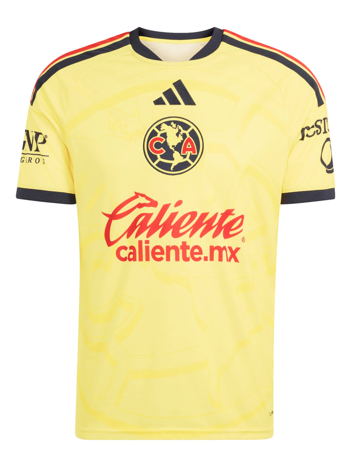 Hombre vistiendo jersey amarillo del Club América y shorts azul marino sosteniendo un balón de fútbol.