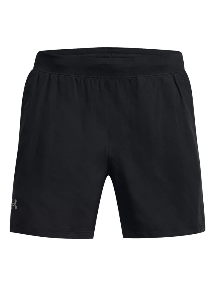 Hombre vistiendo shorts deportivos negros Under Armour, camiseta roja y calzado deportivo blanco con rojo.