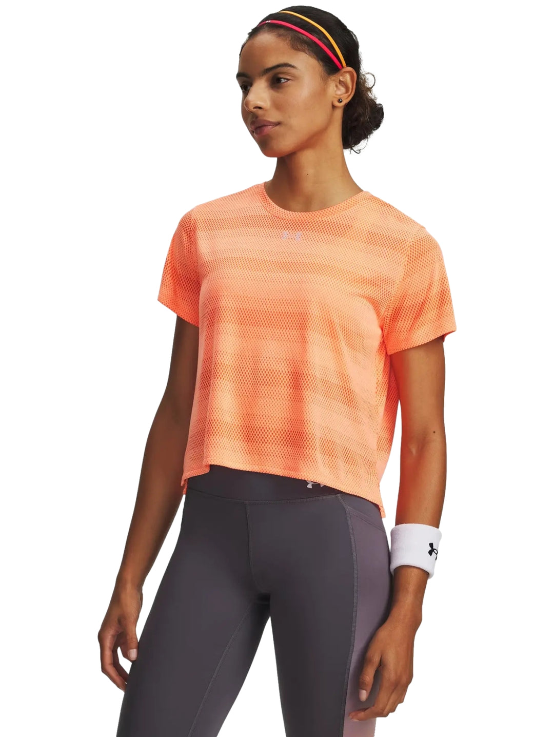 Mujer vistiendo playera deportiva naranja de manga corta marca Under Armour.