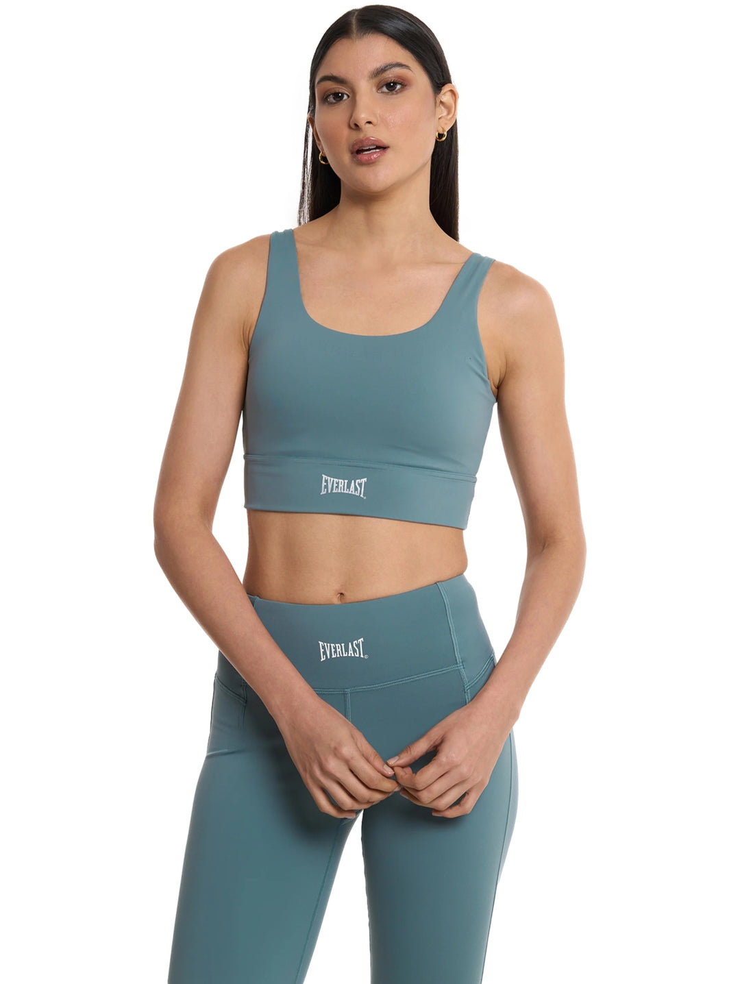 Mujer vistiendo un conjunto deportivo de top corto y leggings en color azul de la marca Everlast.