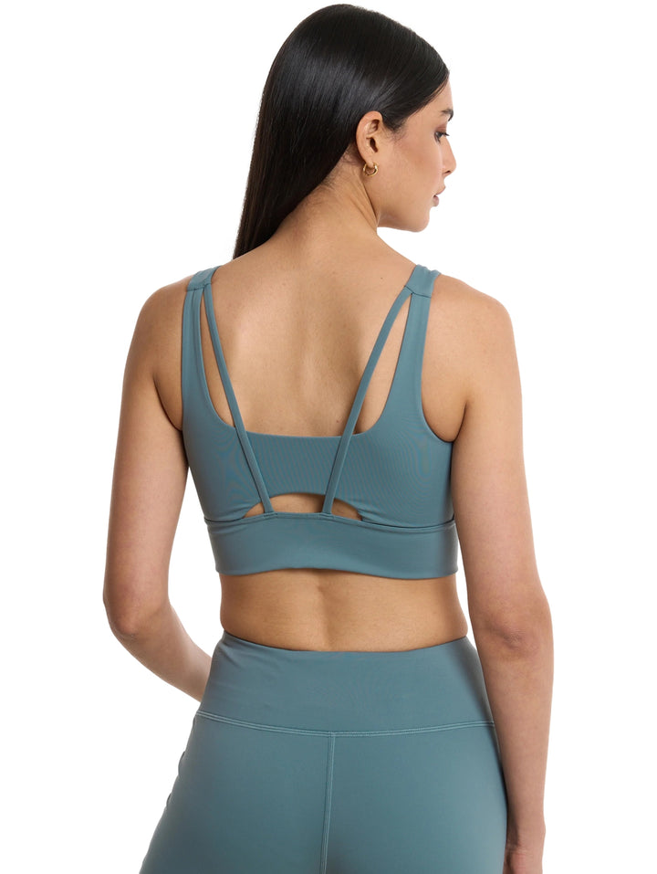 Mujer vistiendo un conjunto deportivo de top corto y leggings en color azul de la marca Everlast.