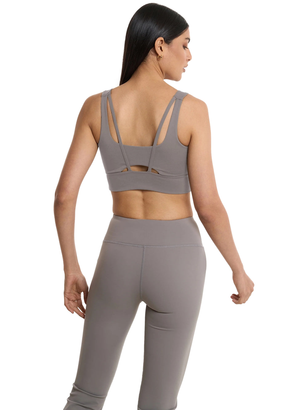 Mujer vistiendo un top corto y leggings deportivos de color gris de la marca Everlast.