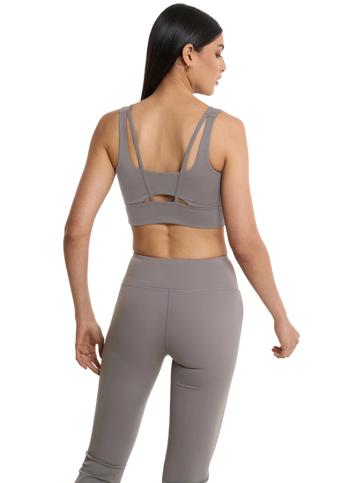 Mujer vistiendo un top corto y leggings deportivos de color gris de la marca Everlast.