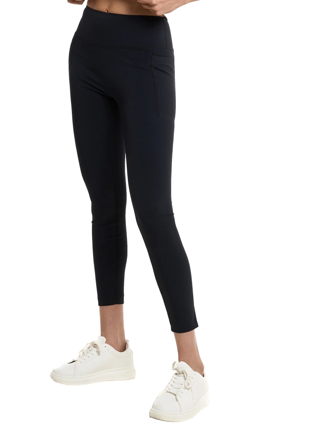 Mujer vistiendo leggings deportivos de color negro marca Everlast y tenis blancos.
