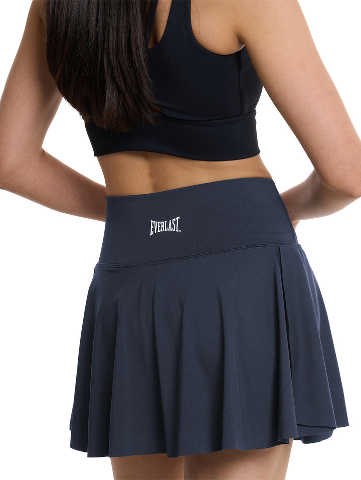 Mujer vistiendo una falda deportiva de color marino de la marca Everlast.