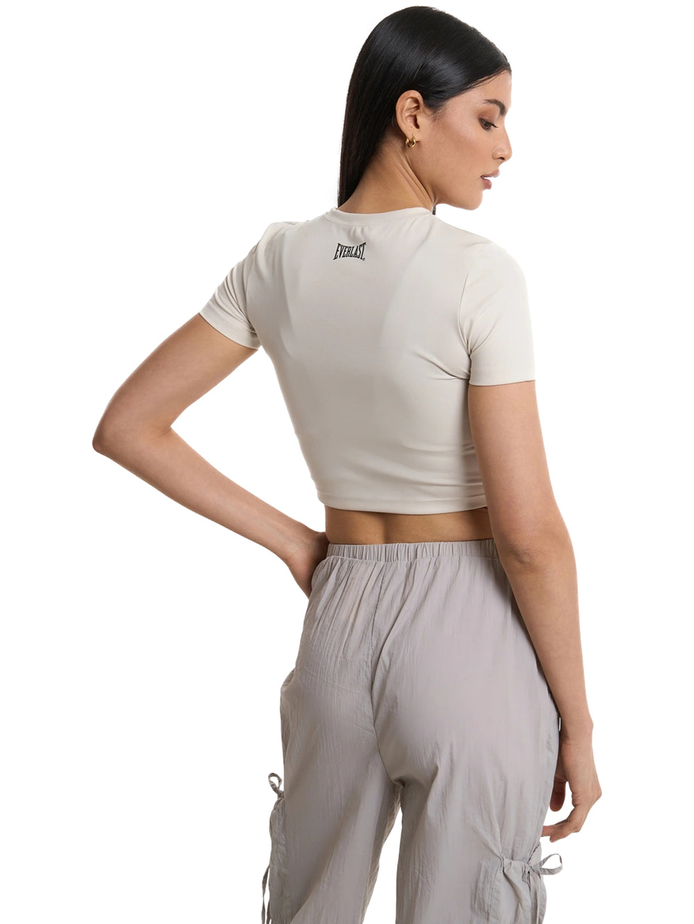 Mujer vistiendo playera corta gris claro de cuello redondo y manga corta.