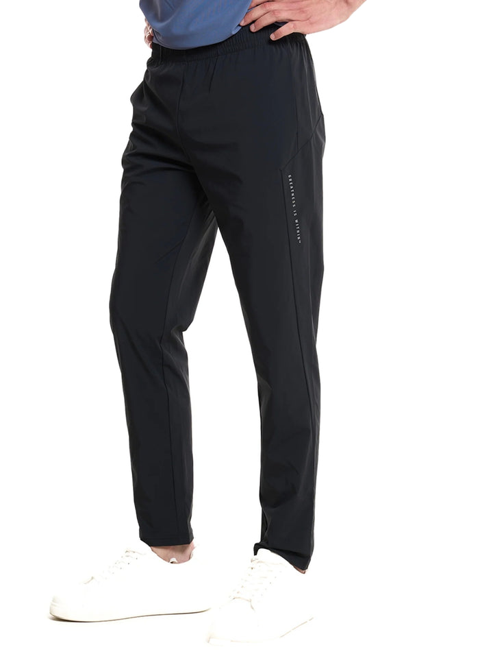 Hombre vistiendo pantalón deportivo negro de Everlast Fitness con calzado blanco.