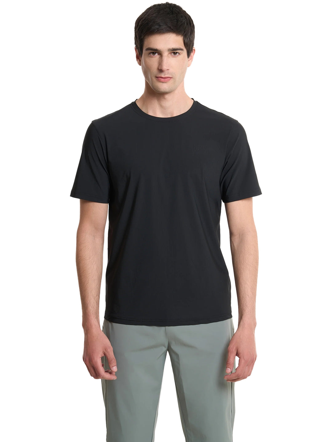 Hombre vistiendo una playera deportiva de color negro de manga corta y cuello redondo.