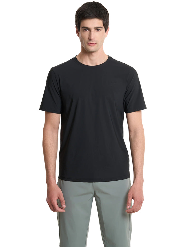 Hombre vistiendo una playera deportiva de color negro de manga corta y cuello redondo.