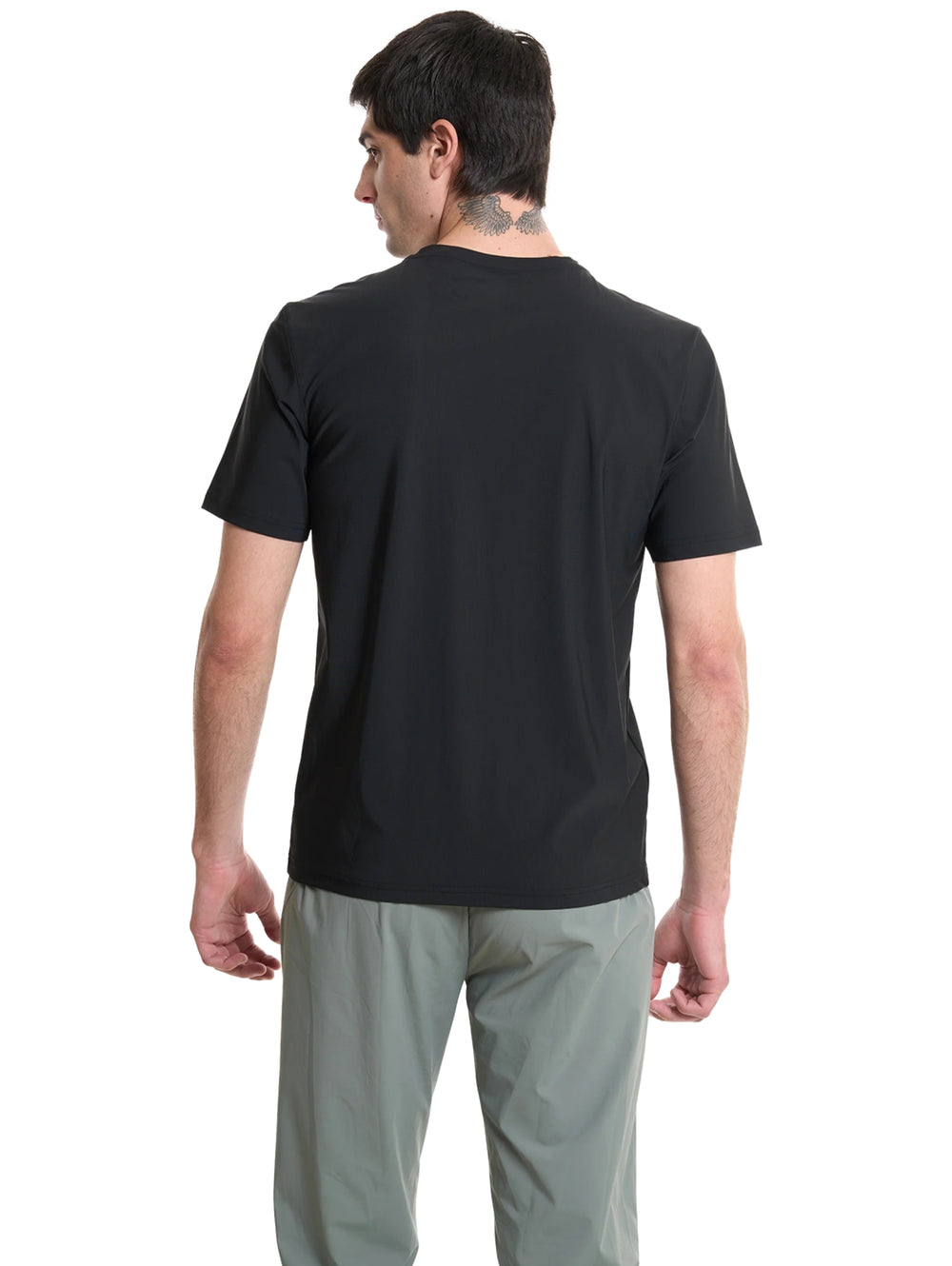 Hombre vistiendo una playera deportiva de color negro de manga corta y cuello redondo.