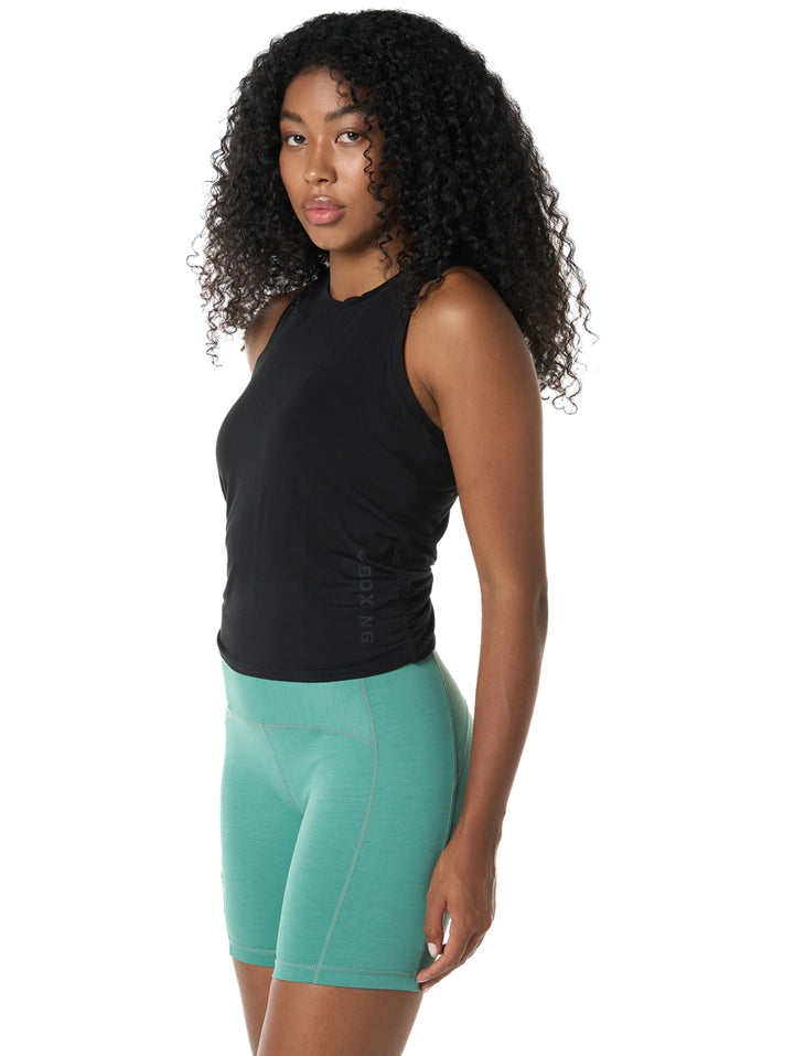 Mujer vistiendo playera deportiva sin mangas color negro.