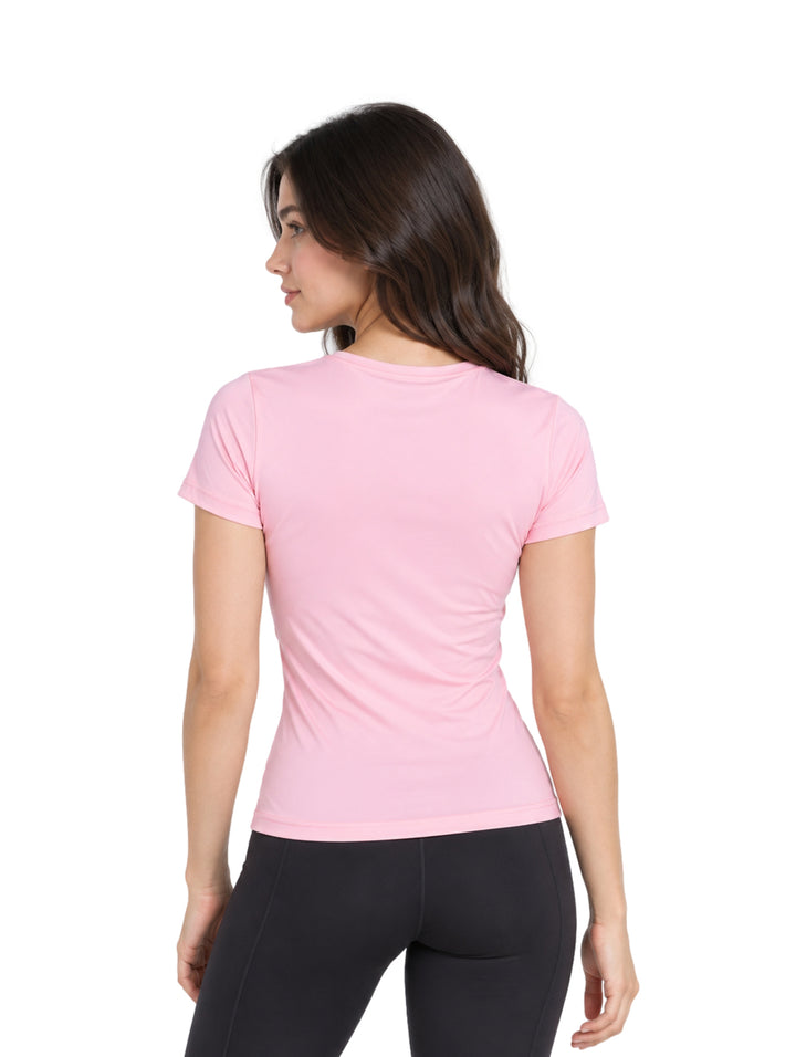 Mujer vistiendo una playera deportiva de color rosa claro de manga corta y corte ajustado.