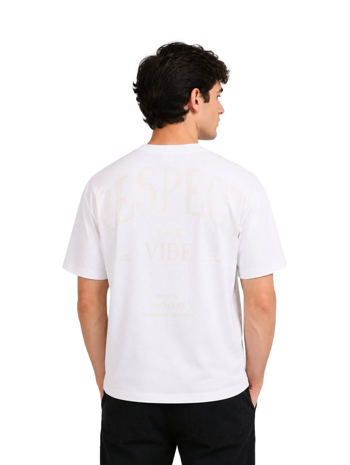 Hombre vistiendo una playera blanca de manga corta con la palabra RESPECT en el pecho.