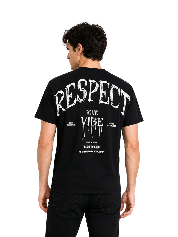 Hombre vistiendo playera negra de manga corta con la palabra RESPECT en letras blancas en el pecho.