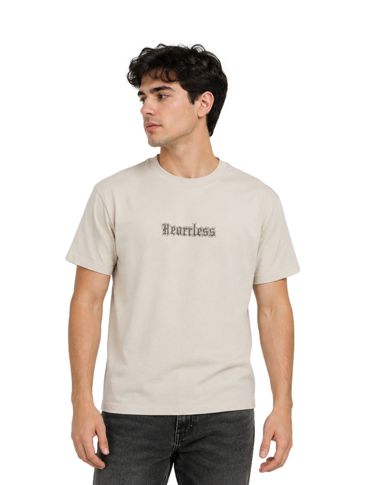 Hombre vistiendo playera color beige de manga corta con estampado frontal.