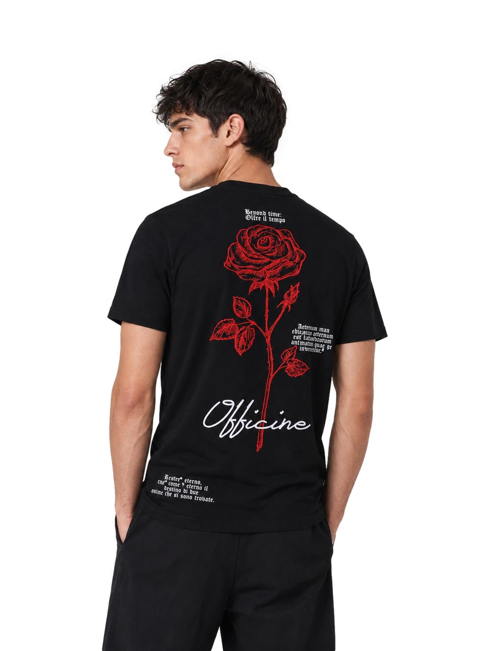 Hombre vistiendo playera negra de manga corta con un pequeño estampado de rosa roja en el pecho.