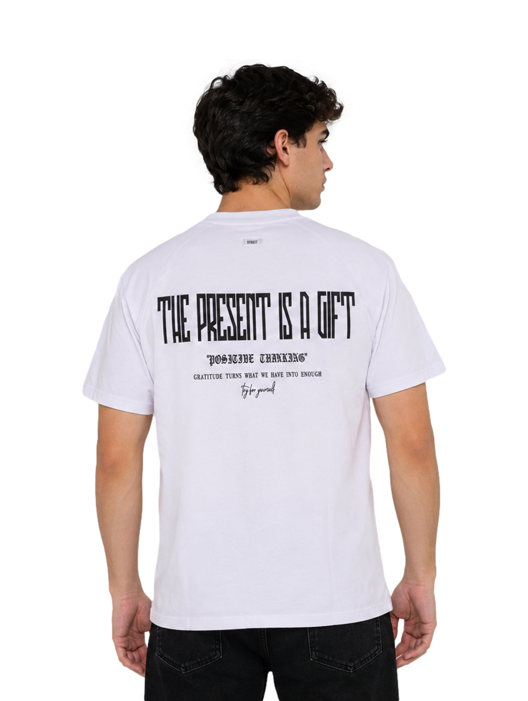 Hombre vistiendo playera blanca de manga corta con estampado pequeño en el pecho.