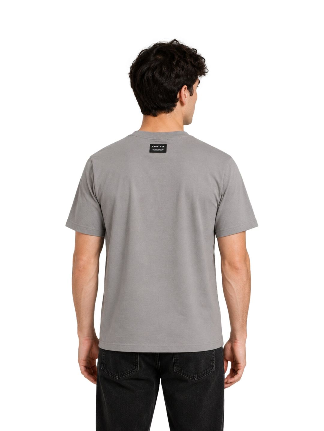 Hombre vistiendo una playera gris de manga corta con texto negro en el pecho.