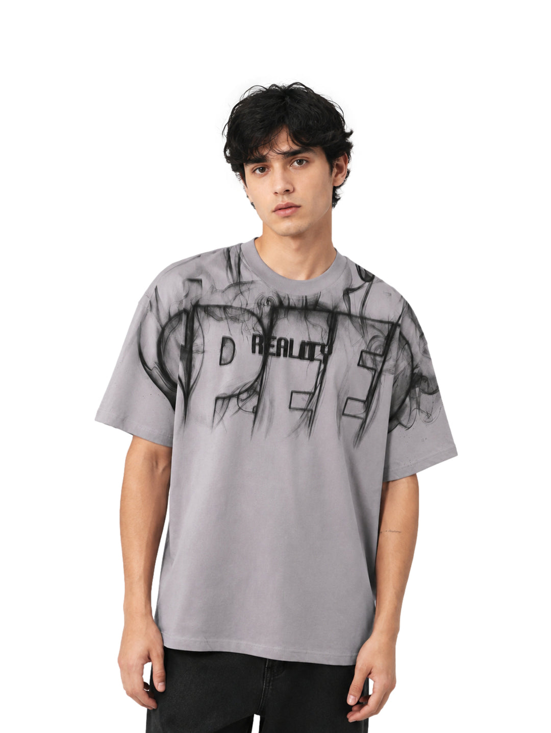 Hombre vistiendo playera color gris de corte amplio con estampado gráfico negro en el pecho.