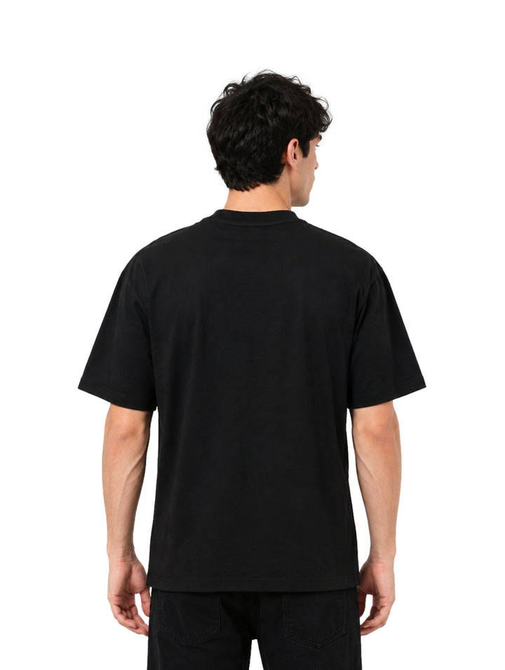 Hombre vistiendo playera negra de manga corta con estampado gráfico blanco en el pecho.
